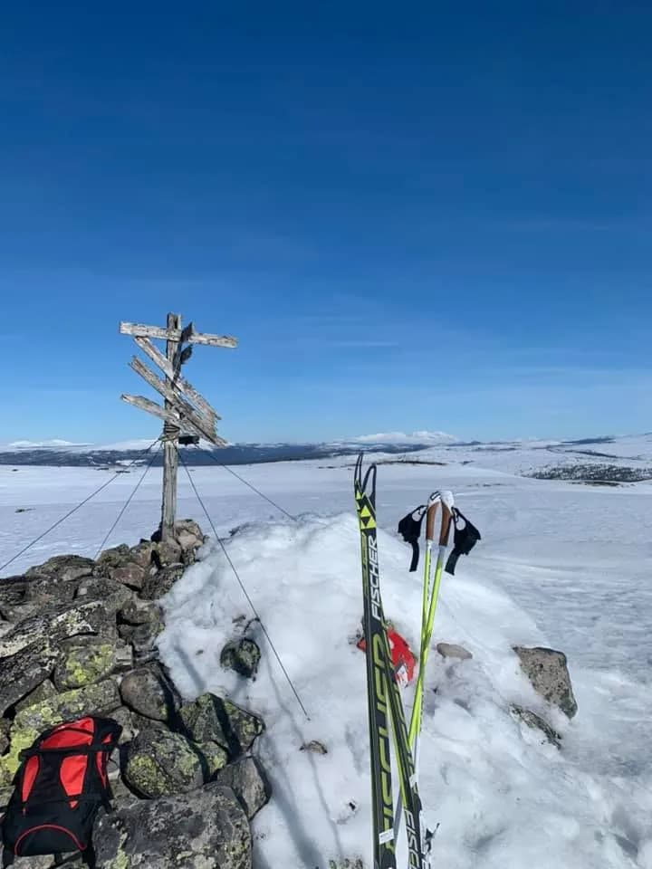 Skis beside a signpost in a snowy landscape